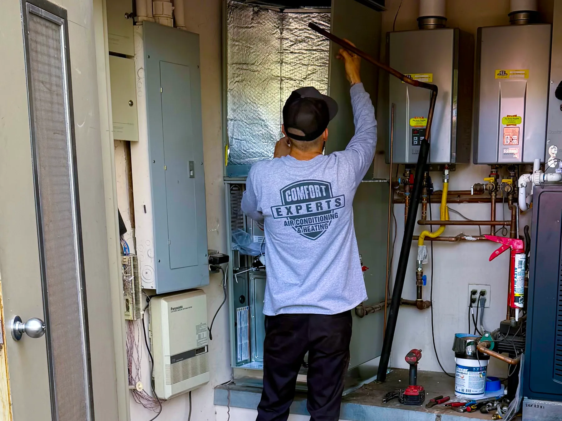 Comfort Experts technician working on indoor HVAC equipment in Scottsdale